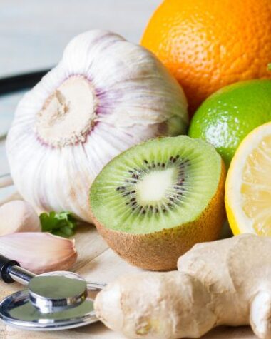 Wpływ odżywiania na odporność dzieci symbolicznie. Na desce kuchennej owoce i warzywa, a obok stetoskop.