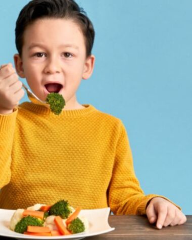 Chłopiec je warzywa. To ważne składniki zbilansowanej diety.