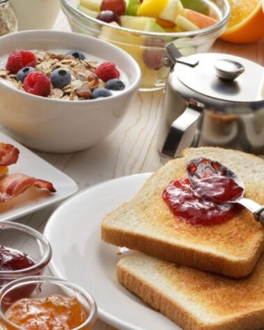 Zdrowe śniadanie – na stole owsianka, tosty, owoce i inne składniki.