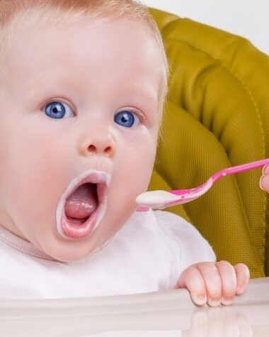 Małe niemowlę karmione przez matkę według metody BLW.