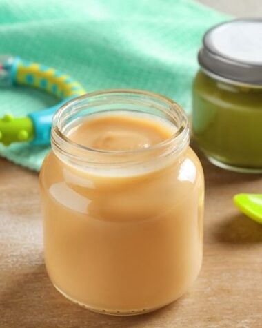 Kolorowe słoiczki dla dzieci ze smacznym pożywieniem ułożone na stole.