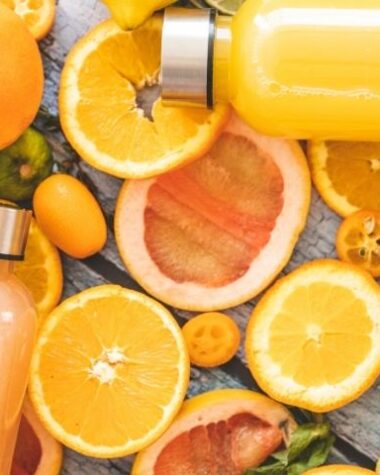 Naturalne produkty, głównie cytrusy, jako źródła witaminy C dla dzieci ułożone na stole.